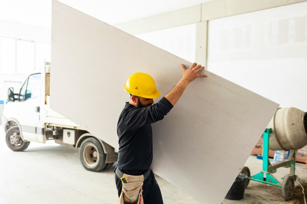 Worker at work in the construction of a plasterboard wall.